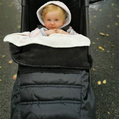bebe sort en hiver dans chancelière poussette chapeau sur tête