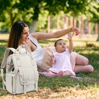 bébé et maman jouent près sac a langer