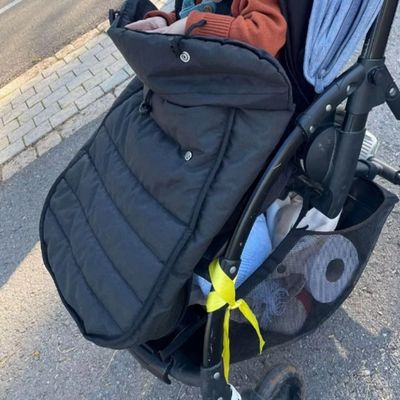 enfant sort bras dans chancelière poussette