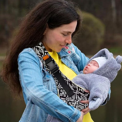 maman regarde flo endormi dans écharpe de portage bébé